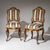 Pair of walnut chairs featuring gilded Rococo appliqués, a serpentine frame, and gracefully curved backs.