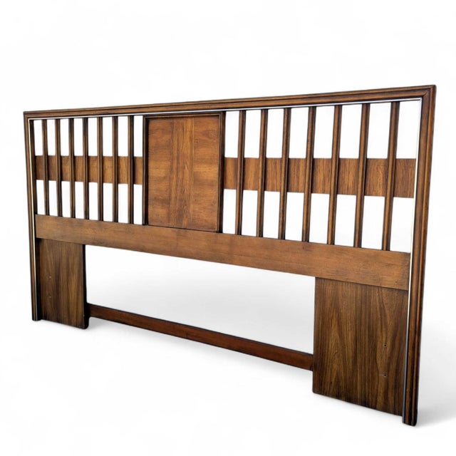 A king-size headboard with richly grained walnut veneer, polished chrome trim, clean horizontal lines and a subtle...