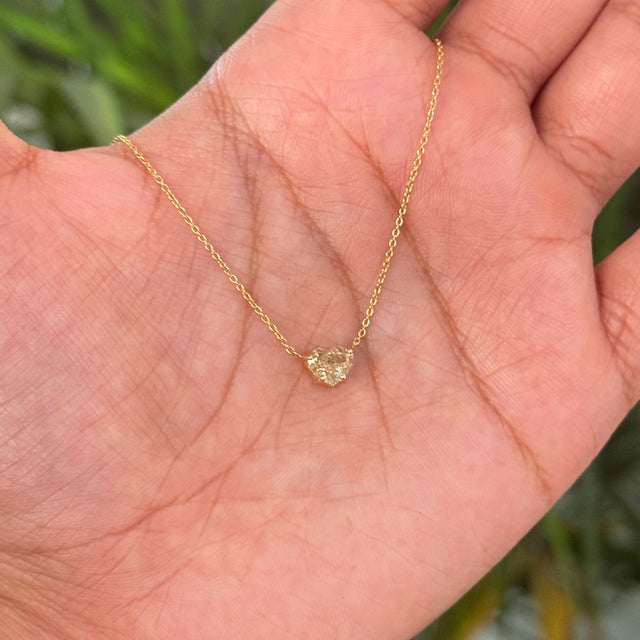 This solitaire pendant necklace featuring a 1 carat heart-shaped yellow diamond, set in 18K yellow gold. The diamond...