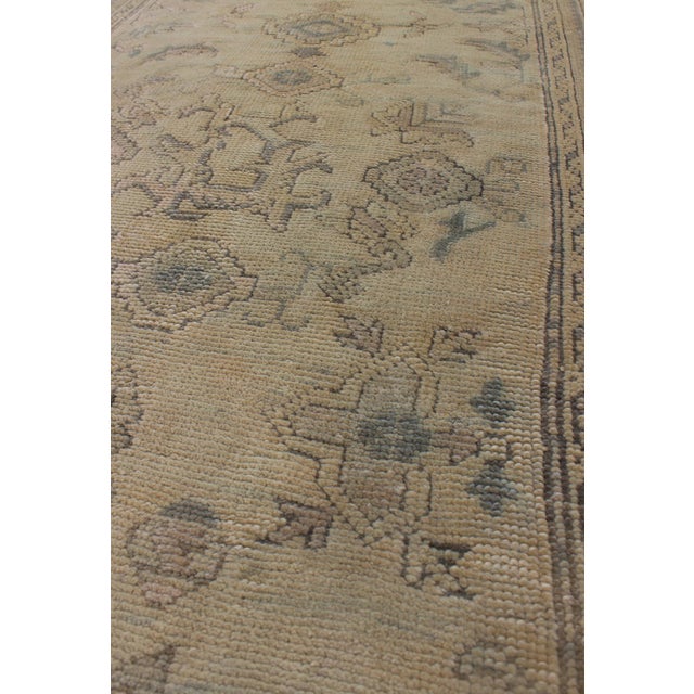 Measures: 2'10 x 12'8. This 1930's antique muted Oushak runner rests beautifully upon a field of elegant cream and taupe....