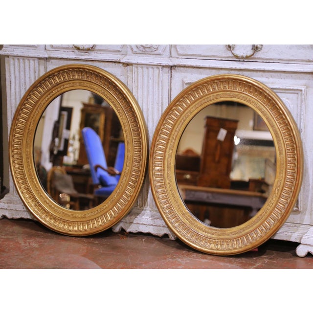 This pair of antique French oval mirrors dates to circa 1860 and is carved from wood with original gilt finishes. The oval...