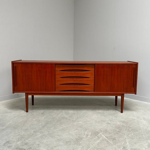 Teak sideboard with 4 drawers and 2 sliding doors, 1960s This piece is designed in the style of the selected designer...