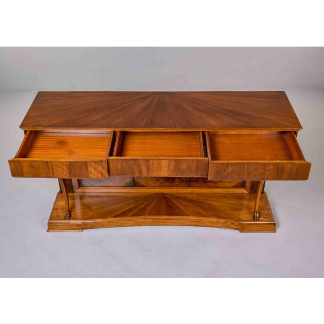 A sophisticated console showcasing exceptional crotch walnut veneered panels and dramatic sunburst marquetry top. Three...