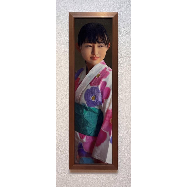 This oil on panel artwork features a young woman adorned in a vibrant kimono, capturing the delicate interplay of light...