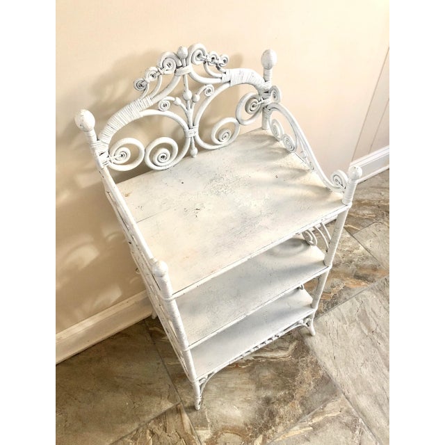 Antique white curly wicker and stick and ball shelf.