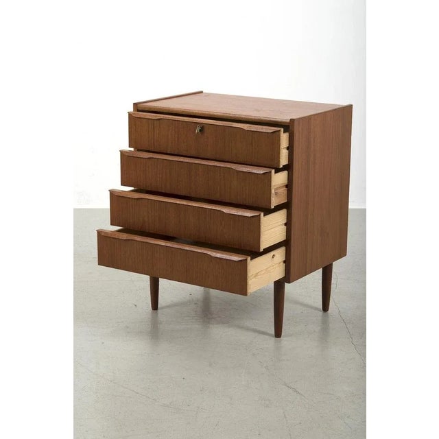 Teak veneer chest of drawers with beautiful shapen handles and 4 drawers. The top drawer can be locked. In good vintage...