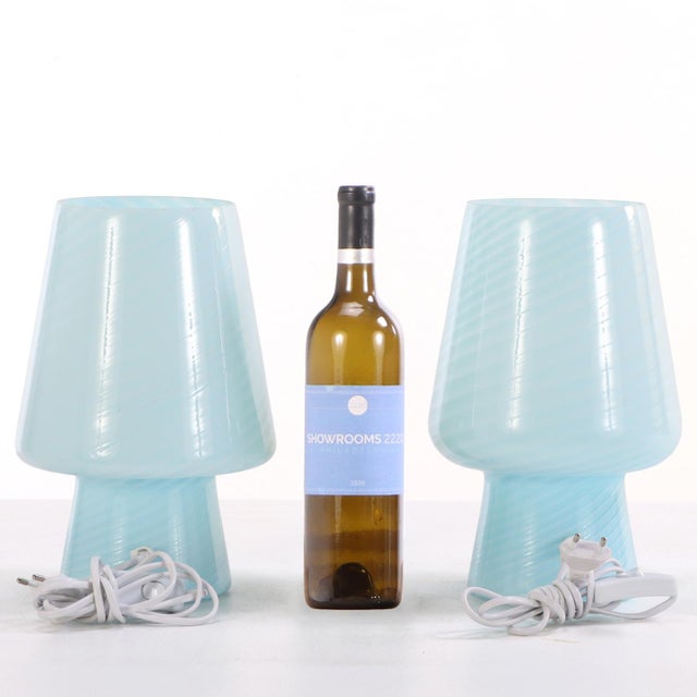 A stylish pair of Italian boudoir lamps crafted in luminous pale blue art glass, embodying the playful sophistication and...