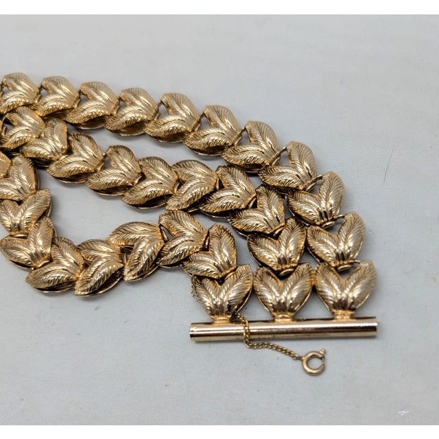 Circa 1950s or 1960s goldtone 3 rows of vs textured like leaves bracelet with slide closure and security chain. It could...