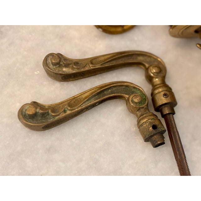 Collection of antique solid brass door handles and escutcheon plates featuring richly detailed designs from the late 1800s...