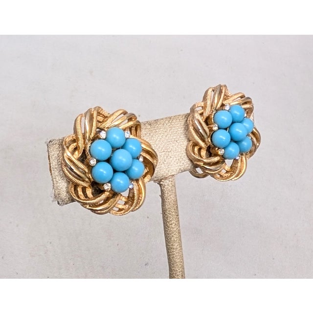 Late 1950s or early 1960s goldtone looped wire edges with a cluster of cabochon faux-turquoise in the center with small...