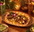 A vintage, large ceramic tray, with an oval-shaped form and embossed floral and fruit designs. The center is decorated...