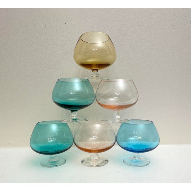 Delicate looking in style, in light pastel shaded colored glass comprise this Mid Century Modern set of six Brandy snifter...