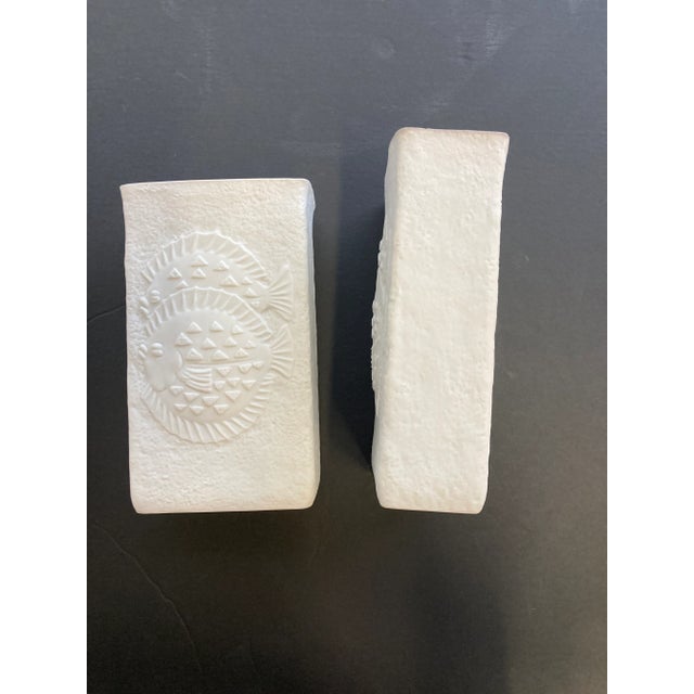 This pair of German vases brings a subtle touch of character with fun detailing of aquatic life balancing the all white...