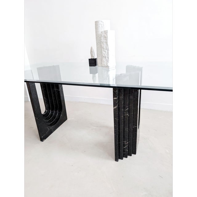 High-end and full-on luxurious dining table consisting of a glass top and a black marble base, designed in the 1970's by...