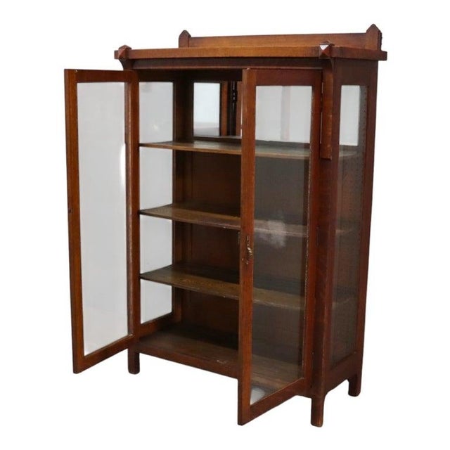 This antique china cabinet, in the manner of Stickley, exemplifies the Arts & Crafts Mission Oak style. Crafted from solid...