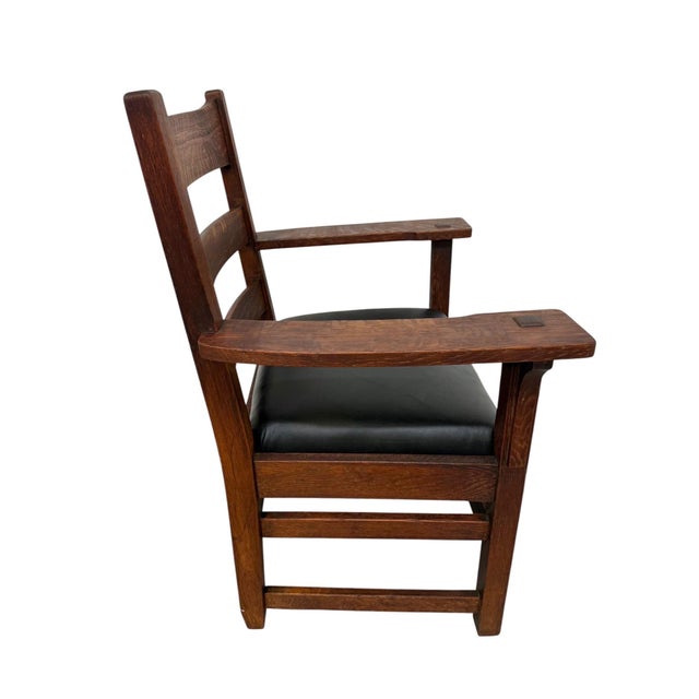 This antique Arts & Crafts Mission oak arm chair embodies the timeless craftsmanship and honest design principles of the...