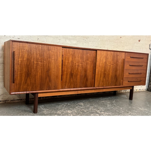 Danish modern server featuring sliding doors, dovetail joinery, and sculpted pulls. Six pull-out drawers and two rows of...