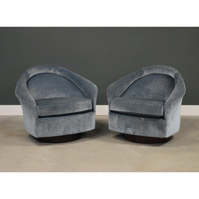 A pair of mid century modern walnut base swivel tilt lounge chairs designed by Adrian an Pearsall for Craft Associates....