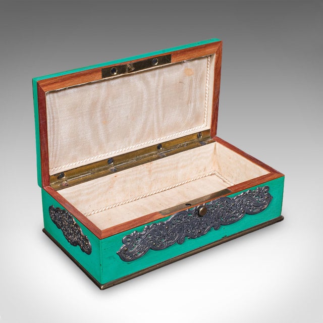 This is a small antique keepsake box. An English, painted mahogany and silver plated trinket case, dating to the Edwardian...