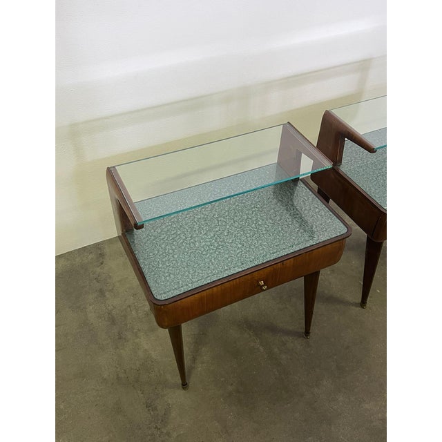 Pair of 1960s walnut bedside tables with glass top and brass details.