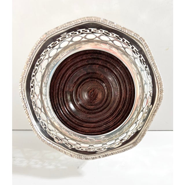 A handsome vintage silverplate wine bottle coaster featuring a solid wood base and elegant pierced gallery with a classic...
