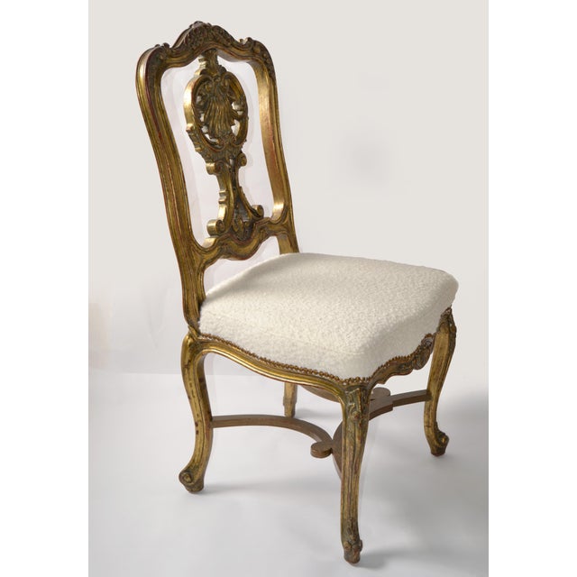 This chair features an ornate, highly decorative antique design with a strong emphasis on craftsmanship and carved detail....