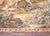 This antique French tapestry, dating to the early 20th century, depicts a classic pastoral scene with figures in a lush,...