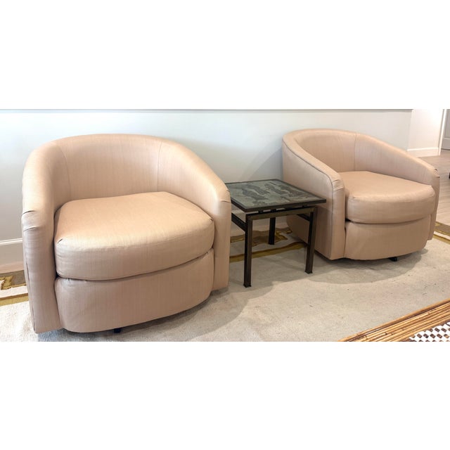 Vintage pair of swivel chairs. Freshly upholstered in a Dedar coated raffia-like neutral colored fabric. Rounded back....