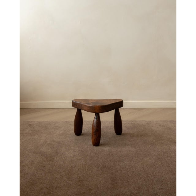A vintage french tripod stool in solid oak, produced in france around the 1950s. With its low proportions, softly...