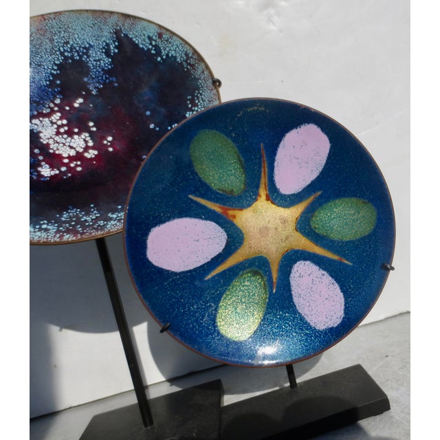 A beautiful pair of two enamels on display stands. steel mounts hold the glossy enamels up as fine abstract disks of...
