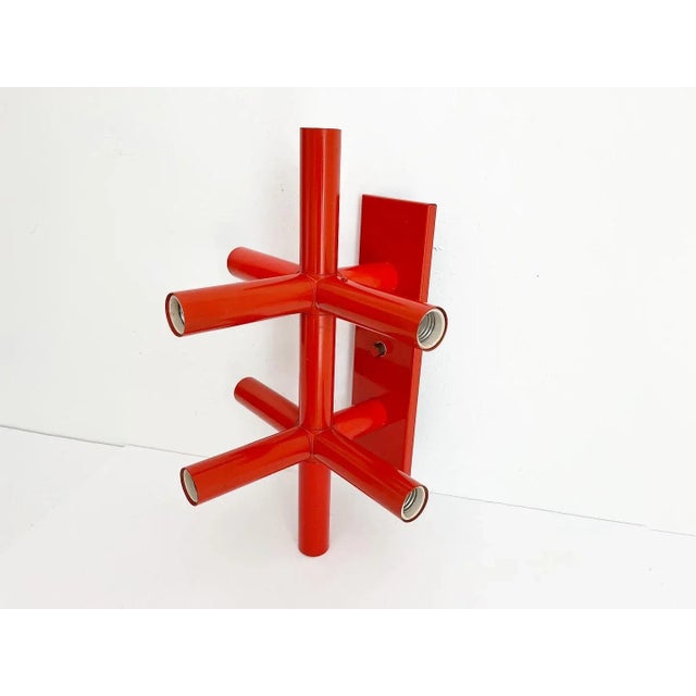 Sculptural atomic modern wall or ceiling light by Lightolier of tubular steel in its original red orange enameled finish...