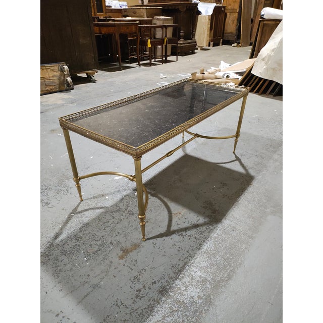 Elegant French Louis XVI–style brass cocktail table dating to the 1940s, featuring a refined neoclassical design and...