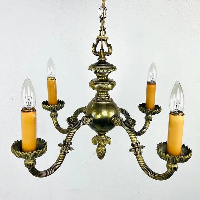 Pair of elegant early 20th Century bronze art nouveau chandeliers. Solid cast bronze with 4 substantial arms featuring...