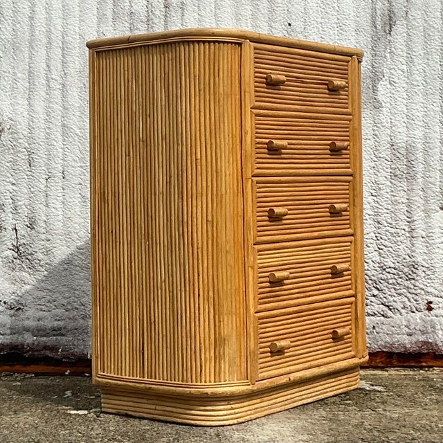 Add a touch of coastal charm to your space with this vintage rattan tall chest of drawers. Its natural woven texture and...