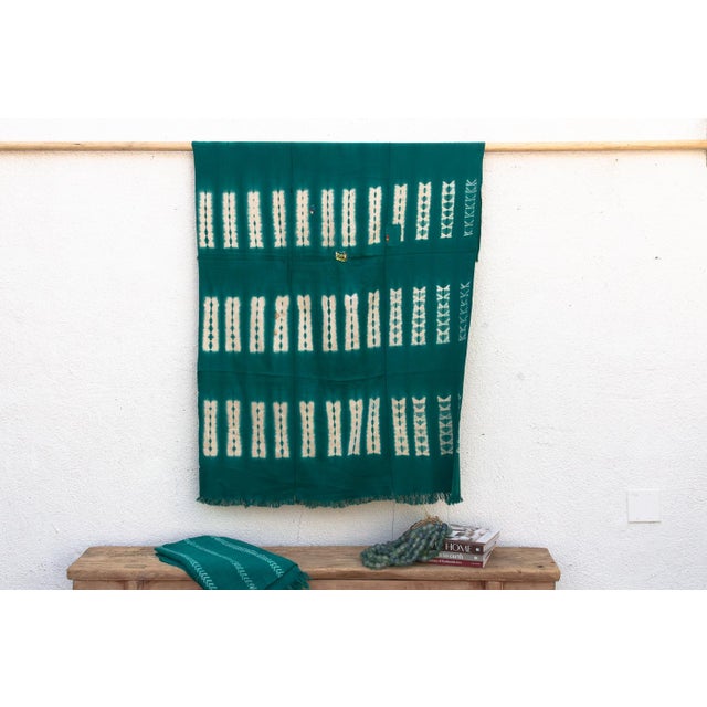 A rare regional variation of West African indigo, featuring saturated teal-green hues and hand-stitched details. This...