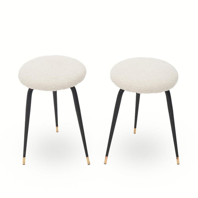 Pair of italian-made stools produced in the 1950s. support structure in black metal. brass feet. circular seat padded and...