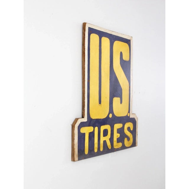 A striking vintage U.S. Tires sign, hand-painted on original composite board in the brand’s classic blue and yellow...