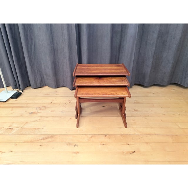 A set of three teak tables from the 1960s. In good condition. The medium-sized table shows some discoloration on the top....
