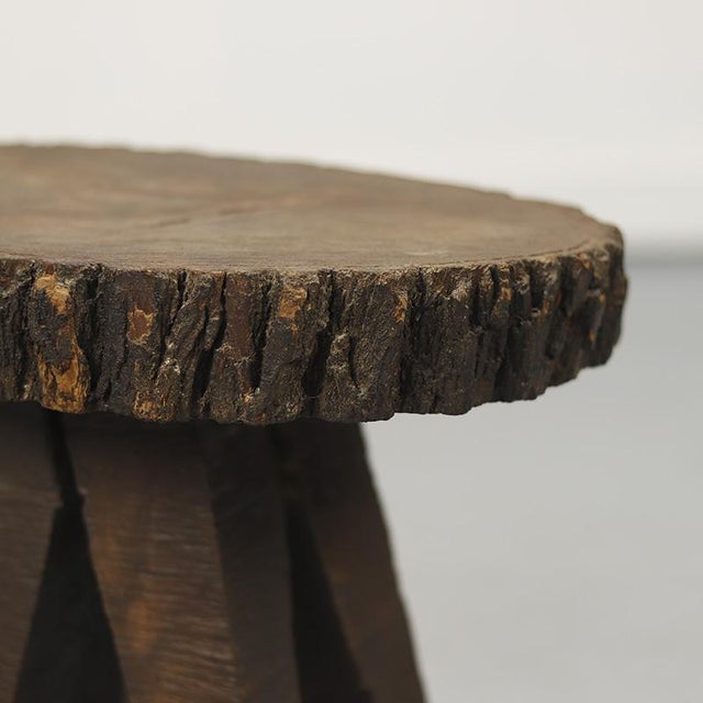 This roughly sawn side table is made from a single piece of pine wood, retaining its natural bark. As a decorative piece...