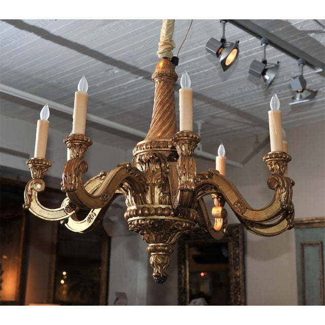 Elegantly carved eight light giltwood chandelier; recently electrified.