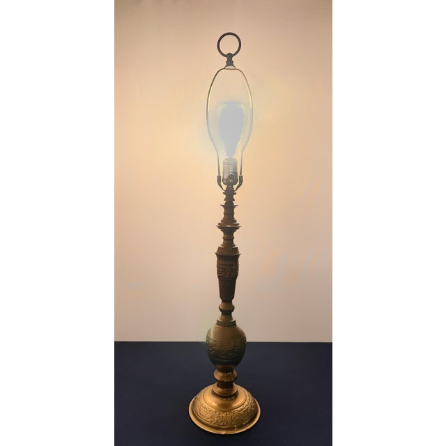 A striking mid-century modern table lamp executed in heavy cast brass with an elegant Asian Chinoiserie silhouette. The...