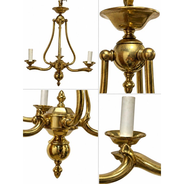 This is a traditional polished-brass chandelier with strong Neoclassical and Federal-style influences. Its design is...