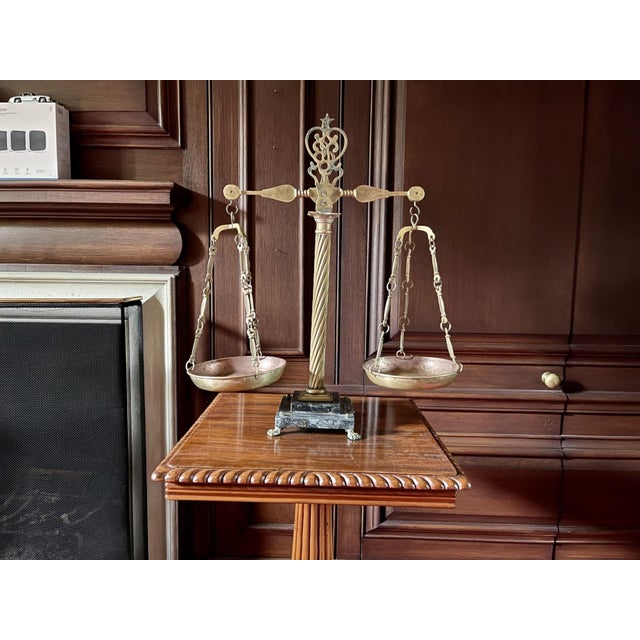 A vintage Italian brass and marble balance scale with a barley twist center column, decorative interlocking chains, two...