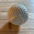 Textured white ceramic planter featuring raised hobnail detailing and a glossy white glaze. The dimensional surface and...