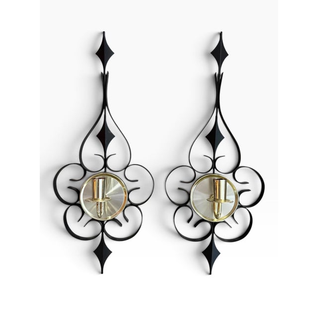 Striking vintage pair of black and gold metal wall sconces featuring an elegant atomic-era silhouette with scrolling...