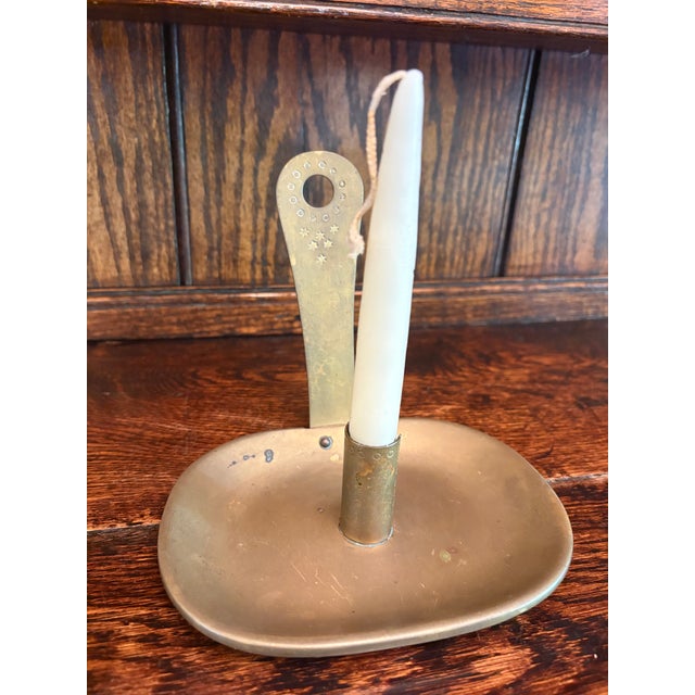 Vintage chamber-style candlestick featuring a shallow oval drip tray, central candle socket, and upright finger loop...