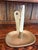 Vintage chamber-style candlestick featuring a shallow oval drip tray, central candle socket, and upright finger loop...