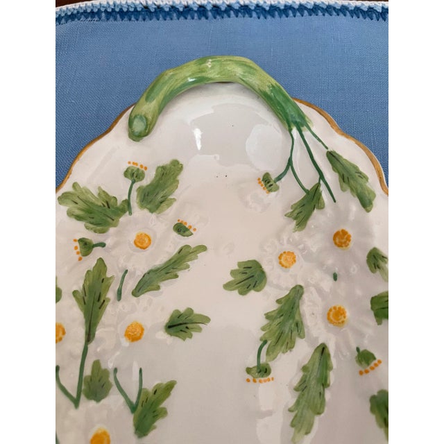 These lovely dishes are designed with hand painted daisies with green branch handles. Each has a gold trim at the edges....
