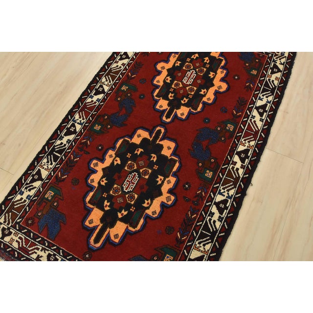 An authentic vintage tribal Baloch rug hand-knotted with fine wool and natural dyes. This nomadic oriental rug features...