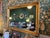 Rectangular, gold-gilded wall mirror with a classic frame featuring fluted inner edges and corner detailing, typical of...